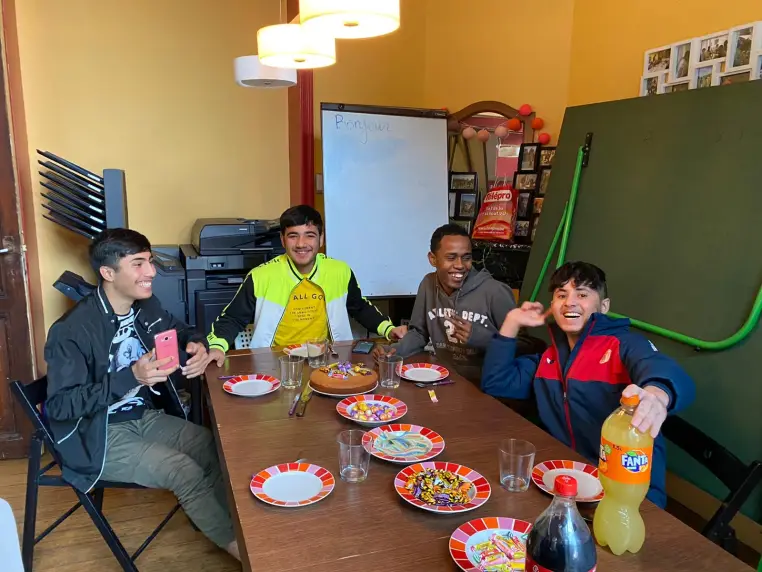Des jeunes attablés devant des assiettes de fête.