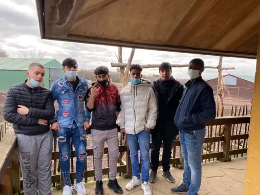 Un groupe de jeunes hommes sous un abri, pendant une sortie.