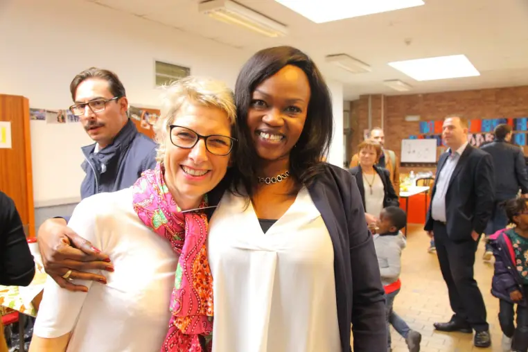 Trois personnes souriantes lors d'une rencontre.