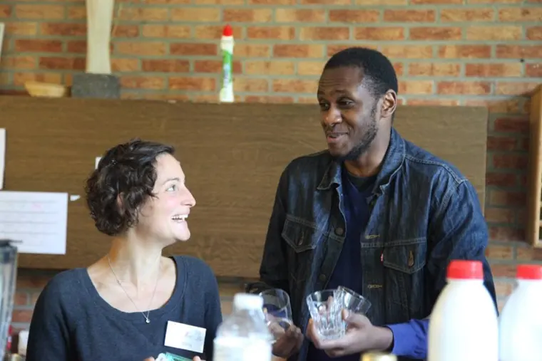 Une femme et un homme souriants derrière des bouteilles de lait.