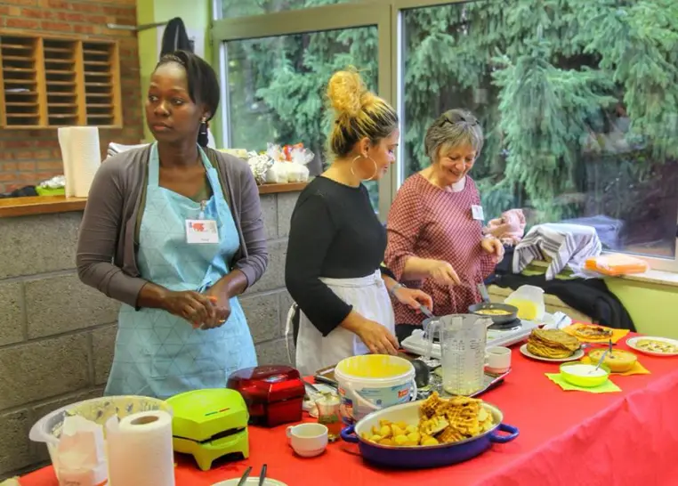 Des femmes préparent un repas lors d'un atelier cuisine.