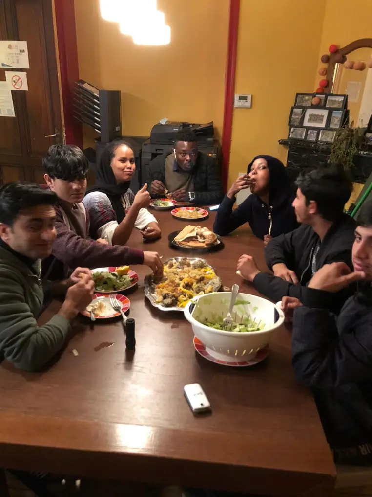 Des jeunes partagent un repas autour d'une table ronde.
