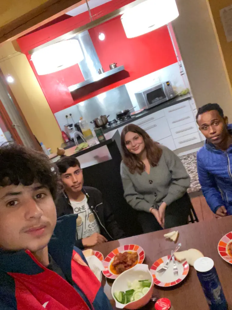 Des jeunes partagent un repas dans une cuisine collective.